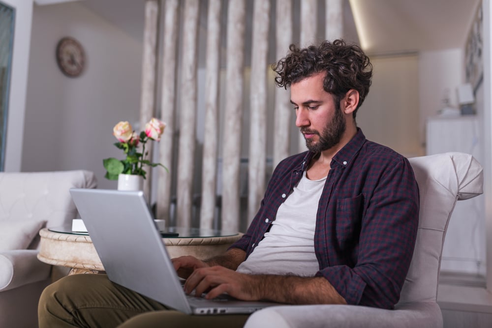 HOMBRE SENTADO TRABAJANDO EN COMPUTADORA SEDENTARISMO HOMEOFFICE CAUSAS DE HEMORROIDES