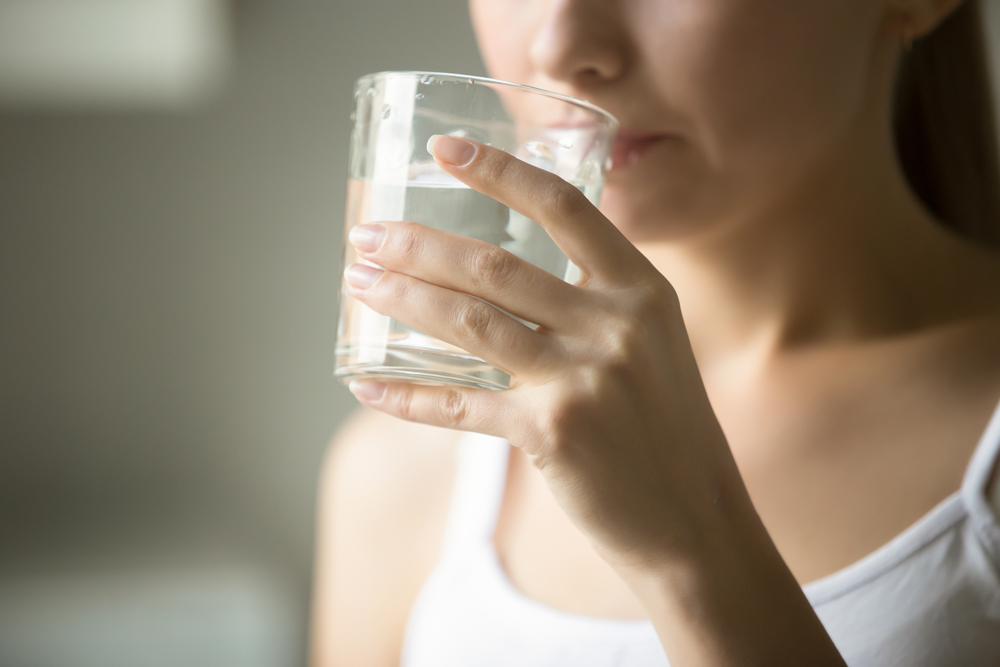 MUJER TOMANDO AGUA CAUSAS DE HEMORROIDES POR QUÉ SALEN HEMORROIDES NO TOMAR SUFICIENTE AGUA HIDRATACIÓN